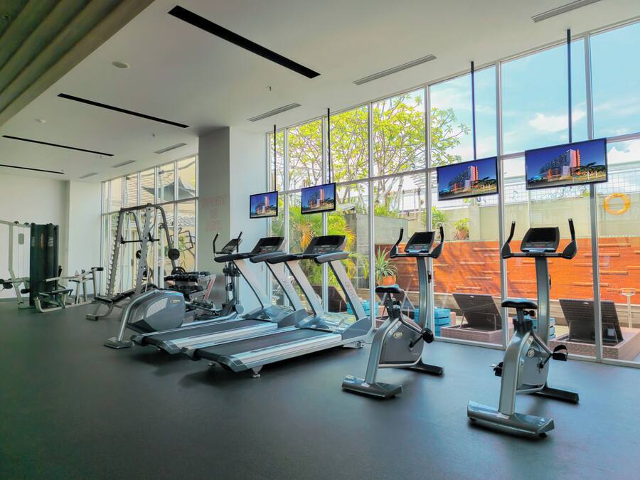 A gym with treadmills, elliptical machines, and weight equipment.