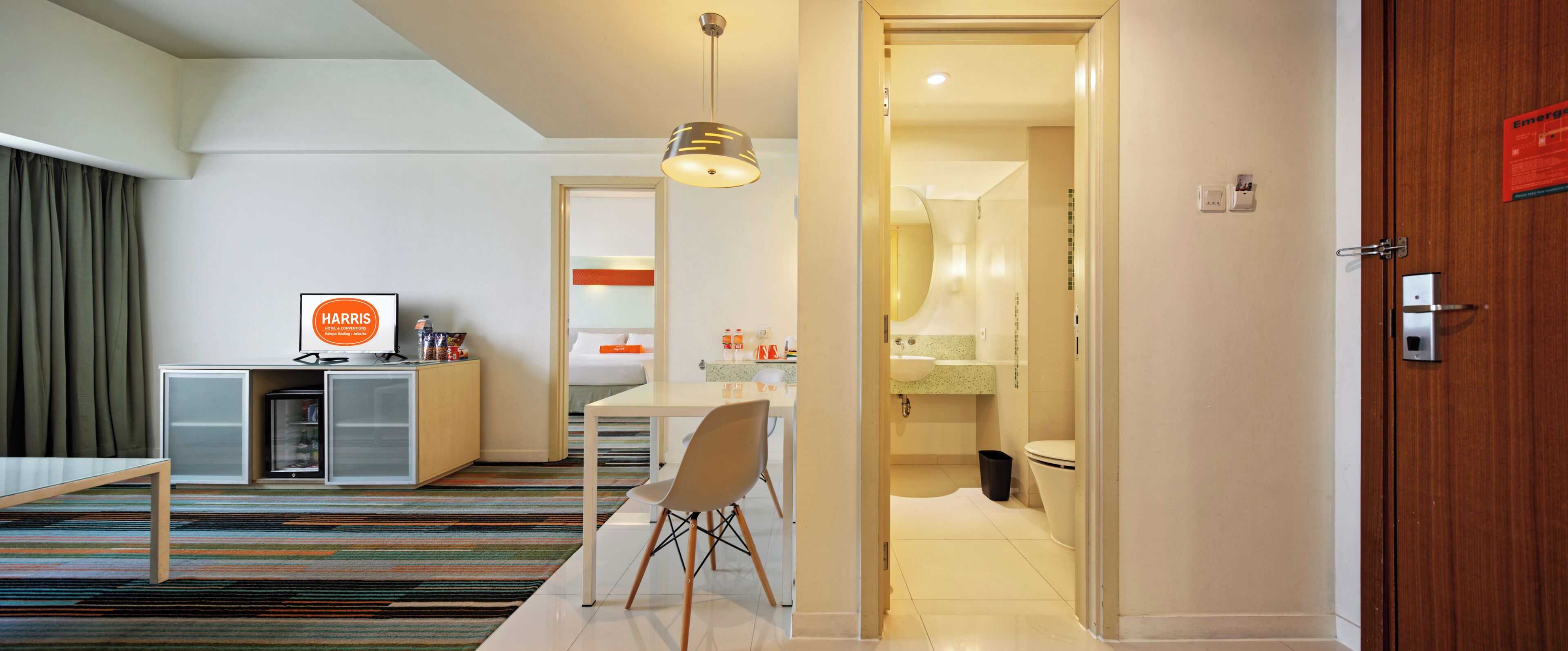 Una habitación de hotel con cama, mesita de noche, escritorio, silla y vista al baño.