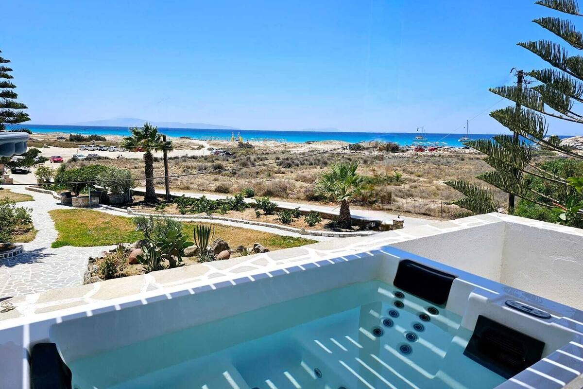 A hot tub with a clear view of the beach and ocean in the background.