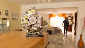 Orologio a forma di nave su un tavolo di legno nella hall di un hotel.
