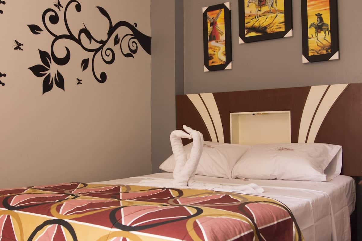 Una habitación de hotel con una cama, decoración en la pared y un adhesivo floral.