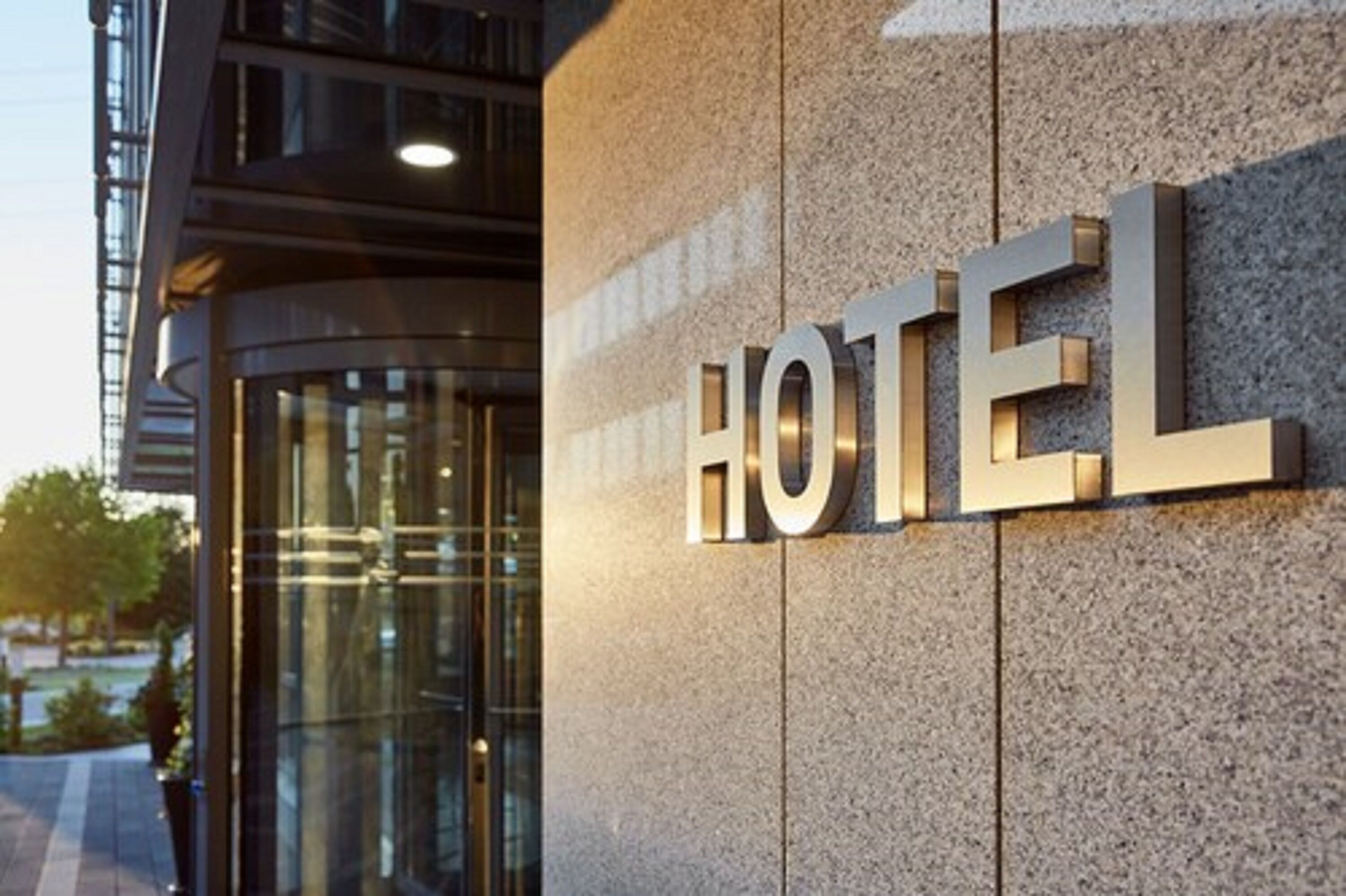 A hotel sign with the word "HOTEL" in large, metallic letters mounted on a textured wall.