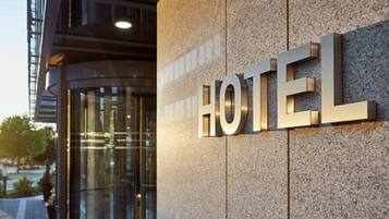 A hotel sign with the word "HOTEL" in large, metallic letters mounted on a textured wall.