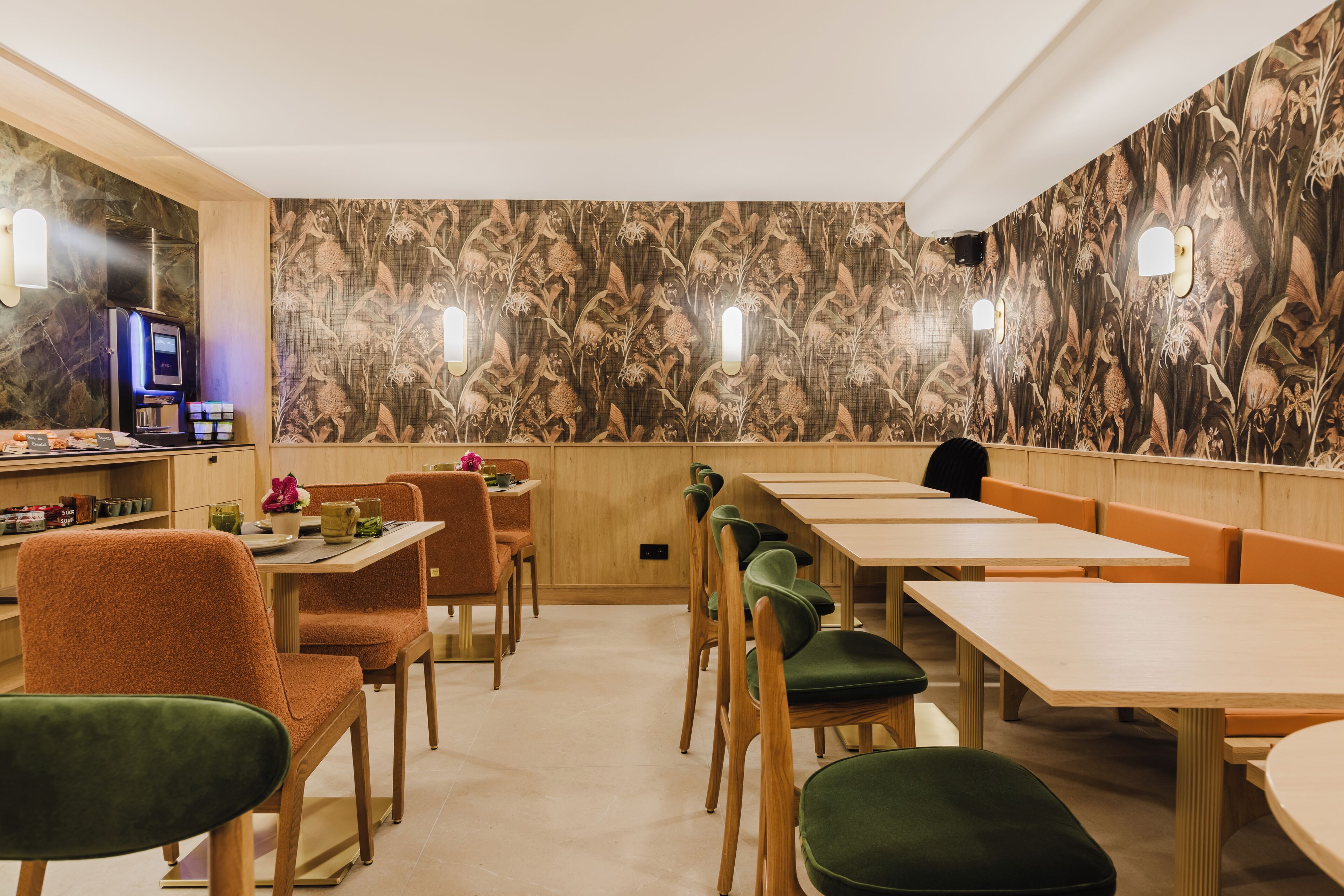 Un restaurante con mesas y sillas de madera, un televisor y un muro con diseño.