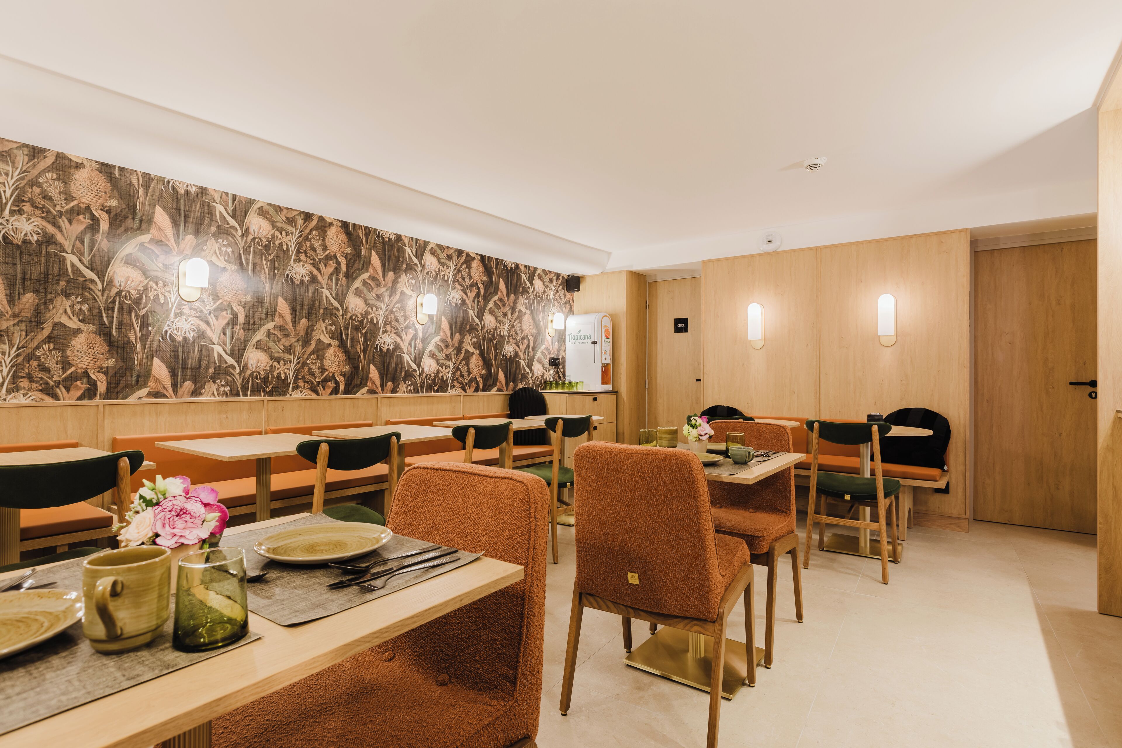 Un restaurante con paredes de madera, varias mesas y sillas.