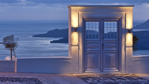 A well-lit entrance with a view of the sea and distant islands. - Petit Palace (Santorini)