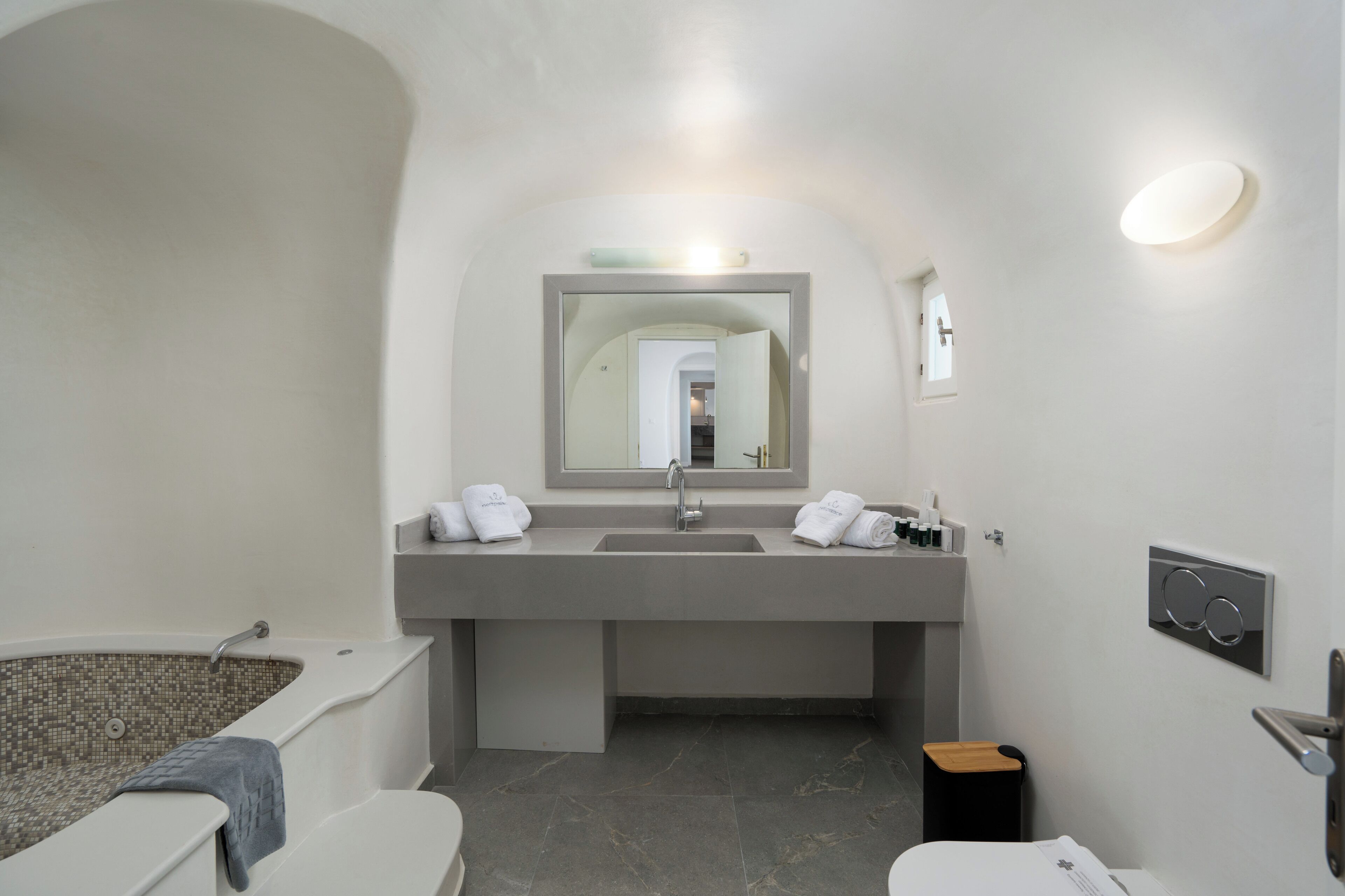 A modern bathroom with a bathtub, a sink, and a mirror.