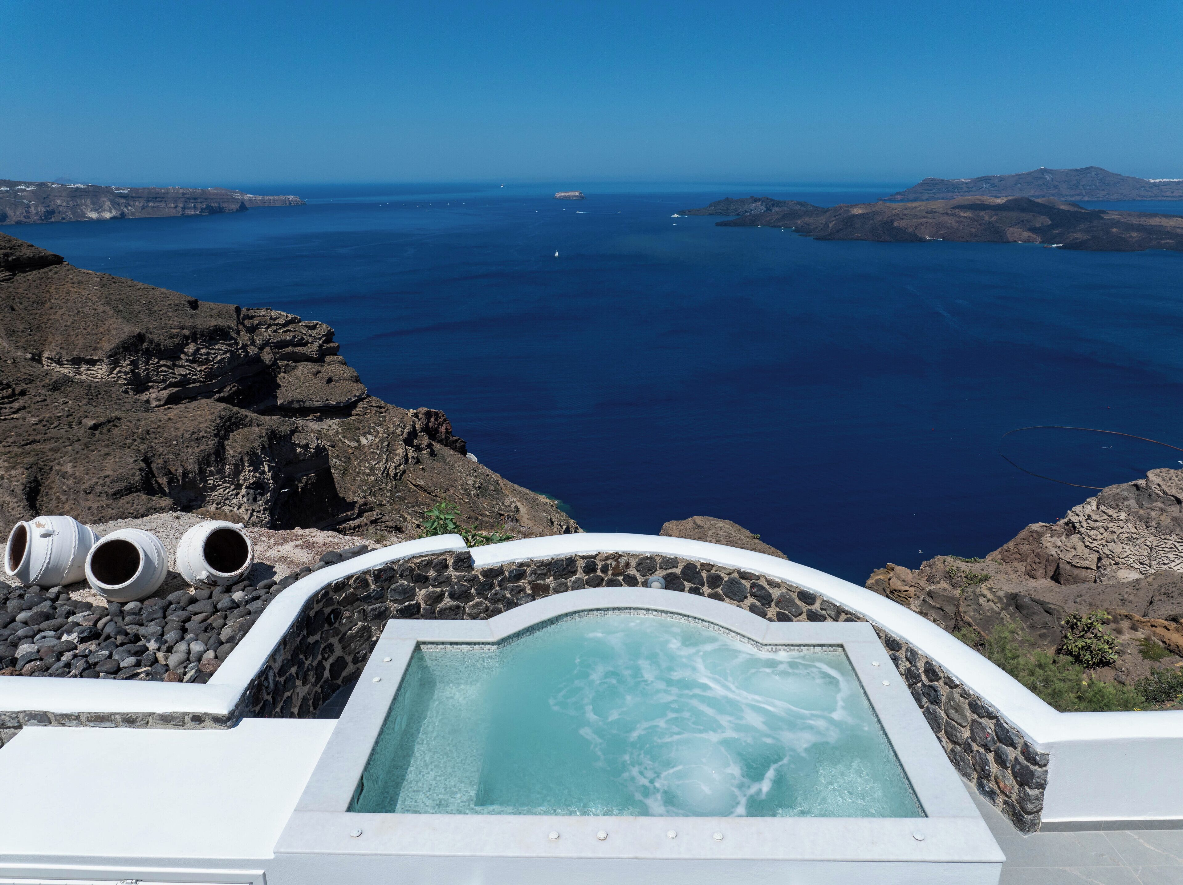 Un jacuzzi con vistas panorámicas al océano y terreno rocoso.