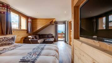 Een gezellige slaapkamer met een bed, een slaapbank en een televisie.