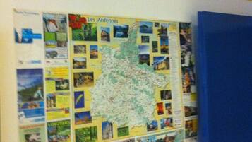 A bulletin board with a map and various travel photos pinned to it.