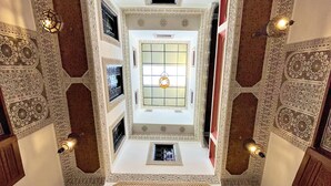 Una habitación con techos altos y detalles geométricos y florales intrincados en las paredes y el techo.