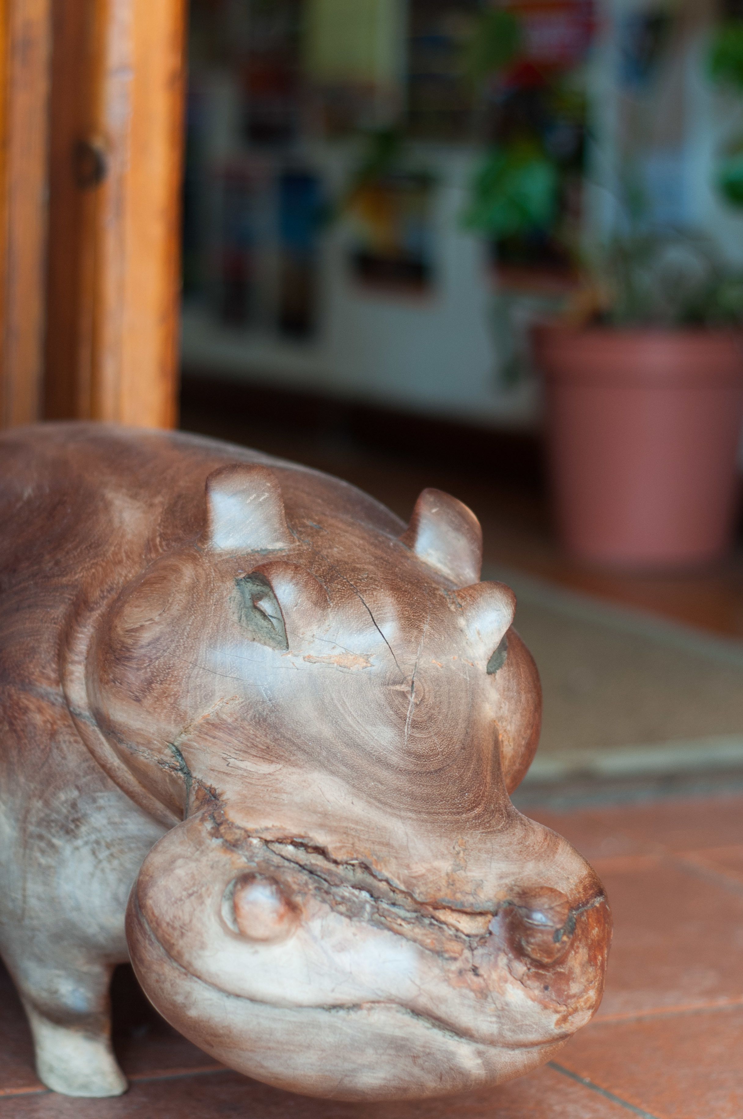 A close-up of a hippo sculpture with a textured surface and visible wear.