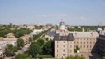 Een groot historisch gebouw met een opvallende koepel en een klokkentoren, gelegen in een stadsgezicht met diverse gebouwen en groen.