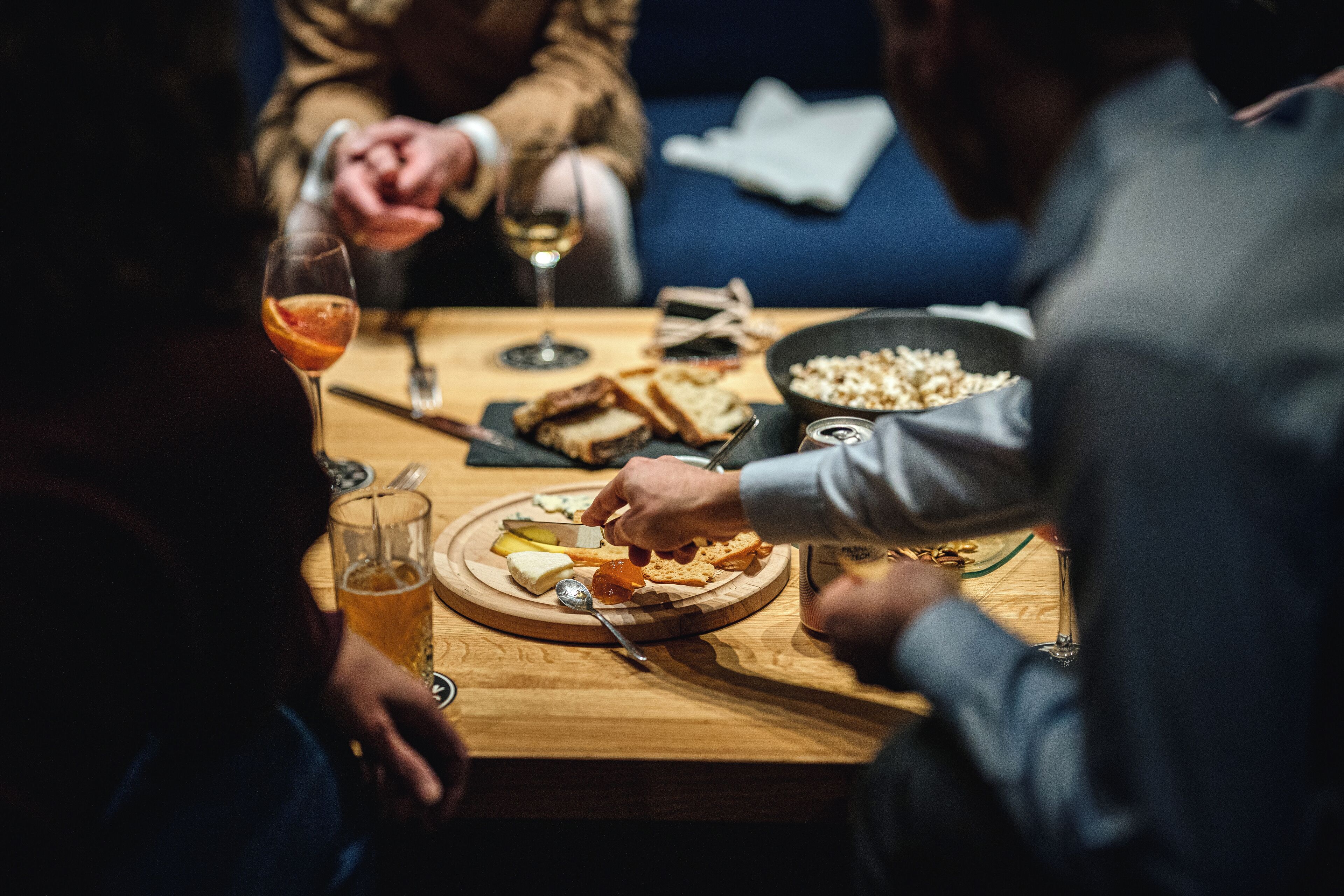 A wooden table with a plate of food, a bowl, and a glass of drink.