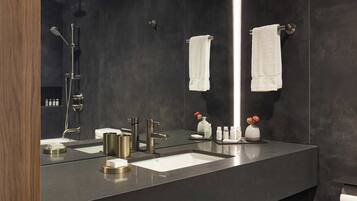 Ein modernes Badezimmer mit großem Spiegel, zwei Waschbecken und einer Dusche.