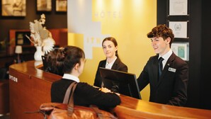 A reception desk with a sign that reads "HOTEL" and a nameplate that says "ITHO". - Hotel de l'ITHQ (Montreal)