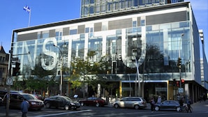 A modern hotel with a large glass facade, a prominent 'STUDIO' sign, and a flag on top. - Hotel de l'ITHQ (Montreal)