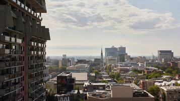 Un edificio alto con varios balcones y un paisaje urbano de fondo.