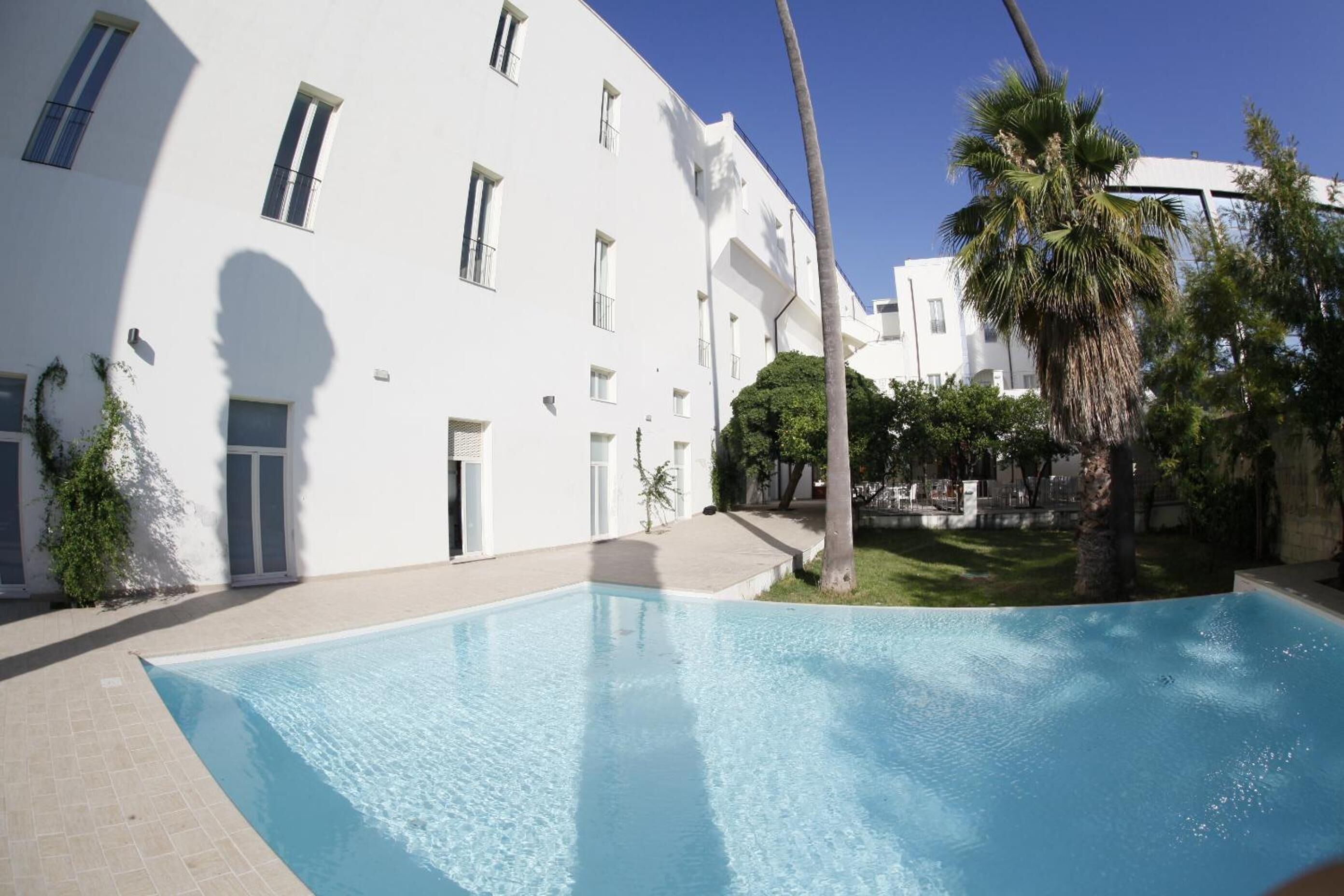 A swimming pool with a white building in the background.