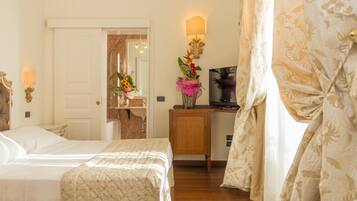 A hotel room with two beds, a wooden nightstand, a TV, and a mirror.