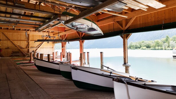Un molo coperto con travi in legno e vista su un lago calmo.