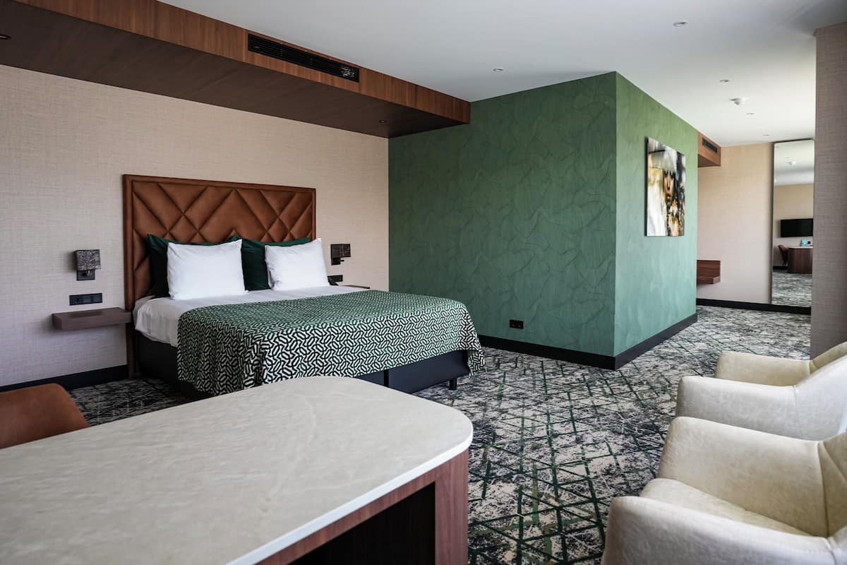 A hotel room with a bed, a desk, and a chair.