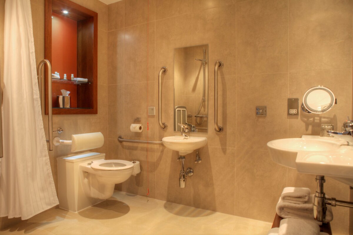 A modern bathroom with a toilet, bidet, and two sinks.