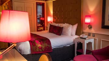 A hotel room with a bed, a desk, a chair, and a nightstand.