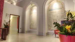 Un vestíbulo amplio con techos altos, arcos y piso de baldosas.