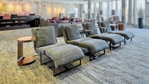 A spacious lobby with multiple seating areas, a reception desk, and large windows providing natural light. - Courtyard by Marriott York (York)