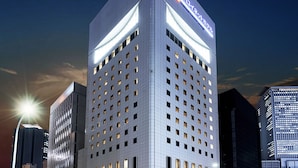 A modern hotel with a prominent sign at the top, multiple floors with evenly spaced windows, and a clear sky in the background. - Daiwa Roynet Hotel Nagoya Shinkansenguchi (Nagoya)