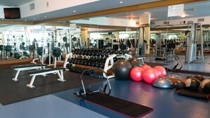 Une salle de sport équipée de matériel de musculation, de ballons d’exercice et d’haltères.