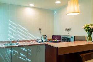 A modern kitchen with a sink, countertop, and a box of Lipton tea.