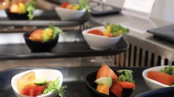 A buffet with various bowls of fruit and vegetables.