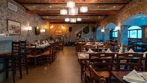 Un restaurant aux murs de briques, aux tables en bois et aux luminaires suspendus.