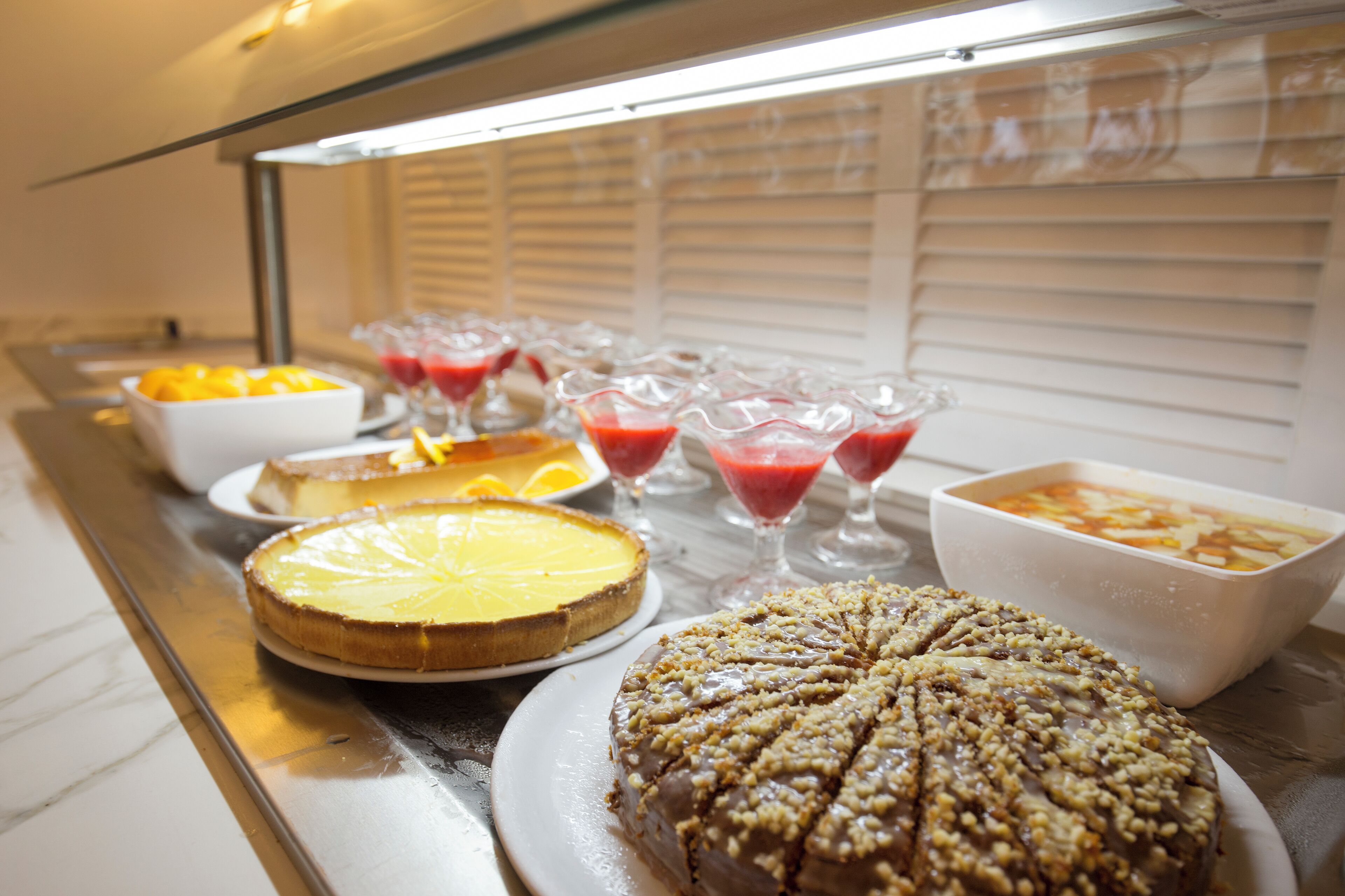Un bufé con diversos postres y bebidas.
