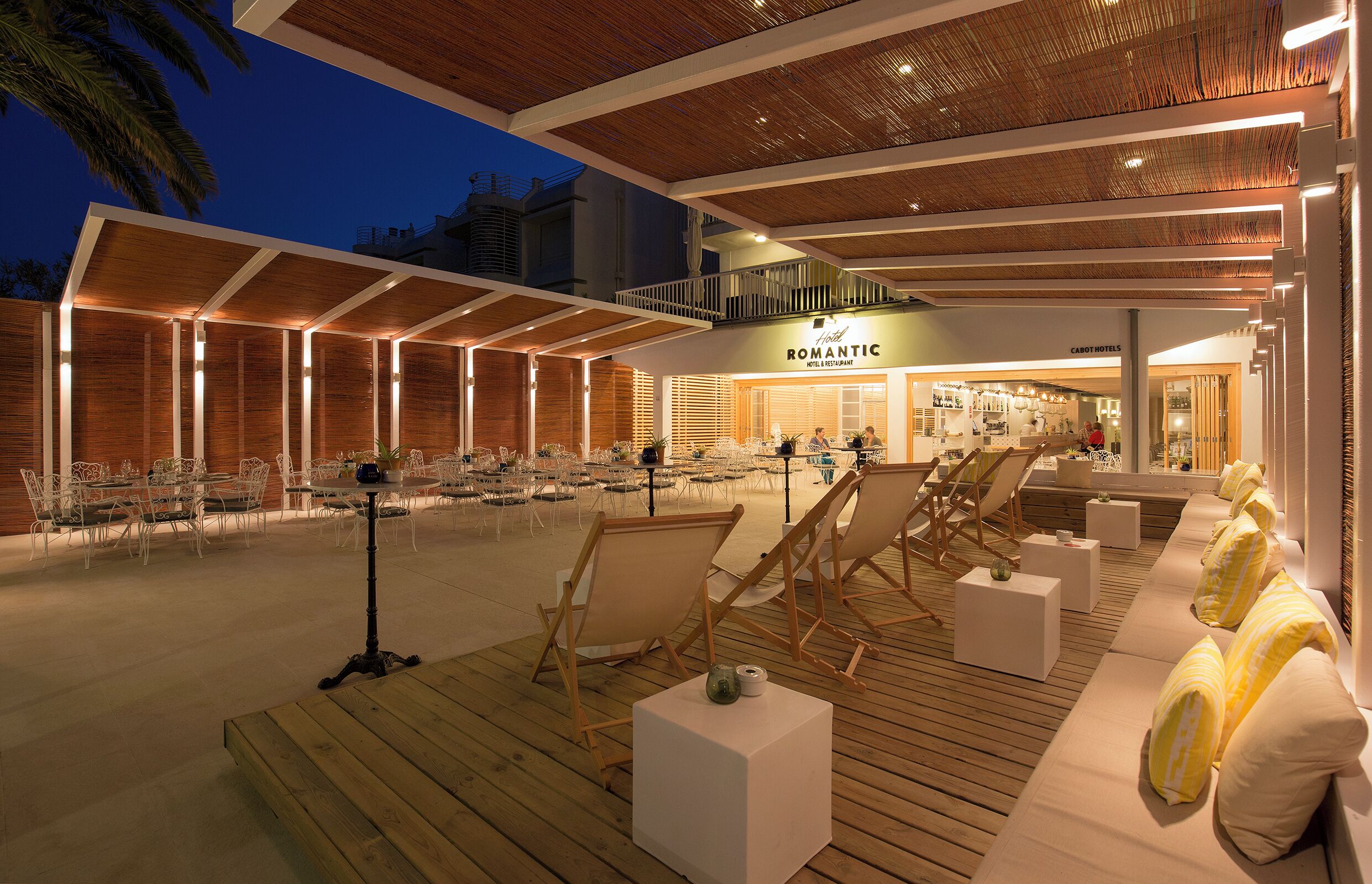 A hotel with outdoor seating, a pool, and a restaurant.