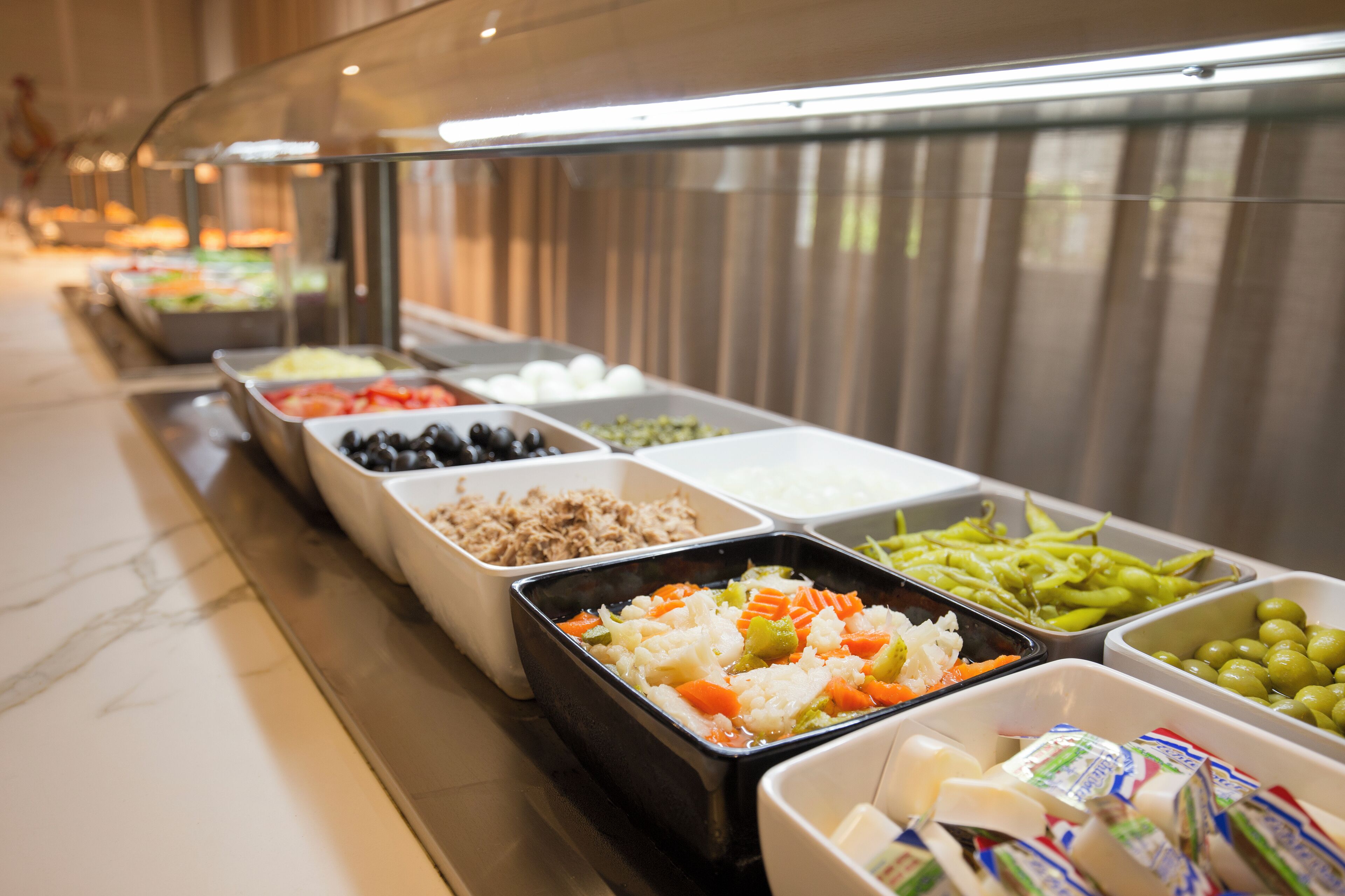 Un bufé con diversas opciones de comida, incluyendo frutas, verduras y productos lácteos.