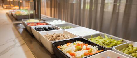 A buffet with various food options including fruits, vegetables, and dairy products.