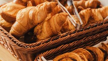 Un bufé de desayuno con cruasanes y una variedad de bollería.
