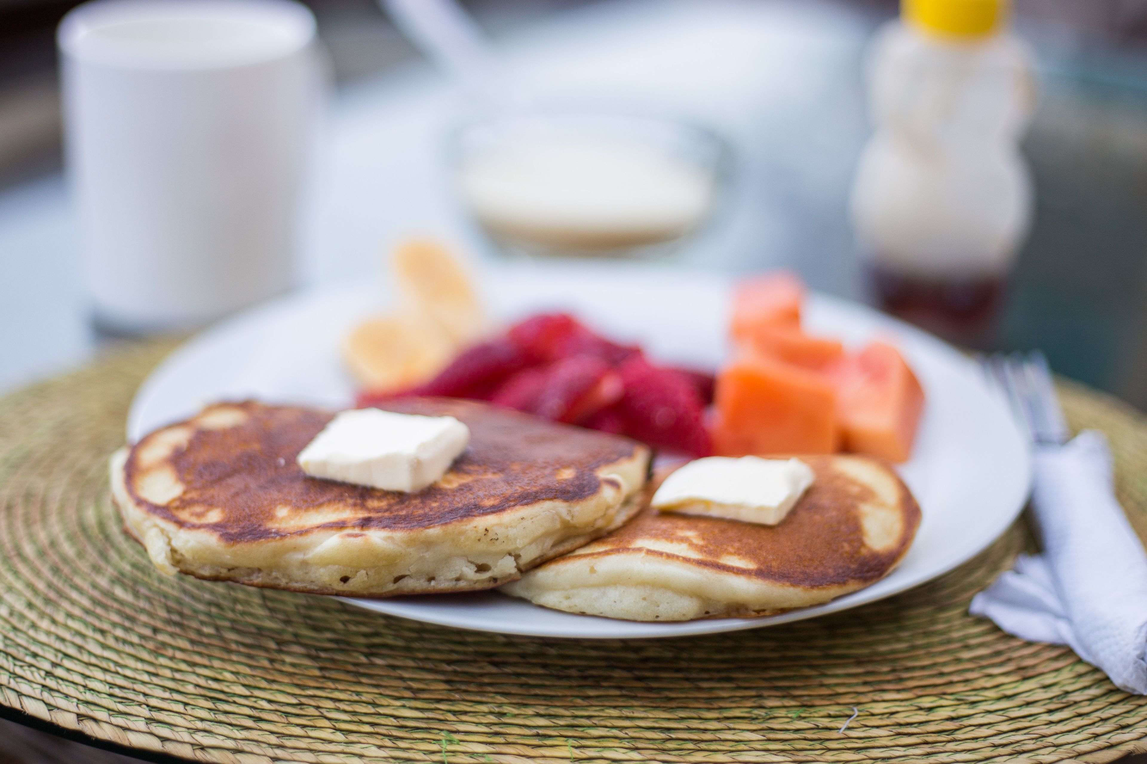 Une assiette de crêpes, de beurre et de fruits.