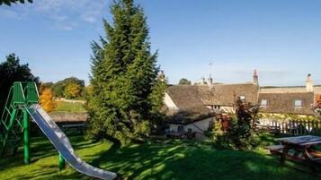 Enjoy a peaceful retreat surrounded by lush greenery and a traditional building with a thatched roof.