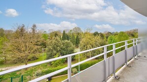 Ein Balkon mit Blick auf einen Park und Bäume.