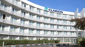 Ein mehrstöckiges Hotel mit einem gut sichtbaren 'CLARION'-Schild, Balkonen und einem angelegten Innenhof.