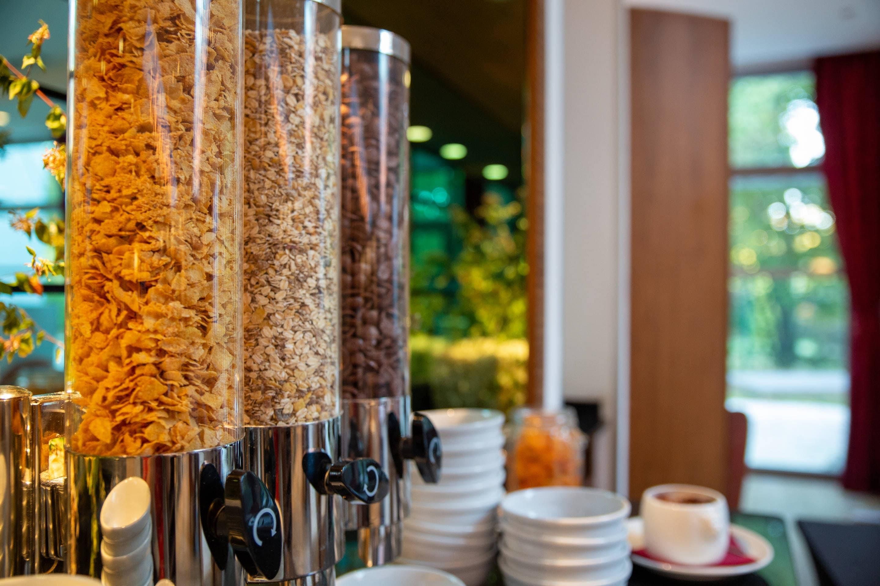 A breakfast station with multiple dispensers of cereal and coffee.