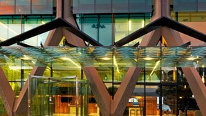 A modern hotel entrance with a glass facade, geometric architectural design, and a visible reception area. - Novotel Auckland Airport (Auckland)