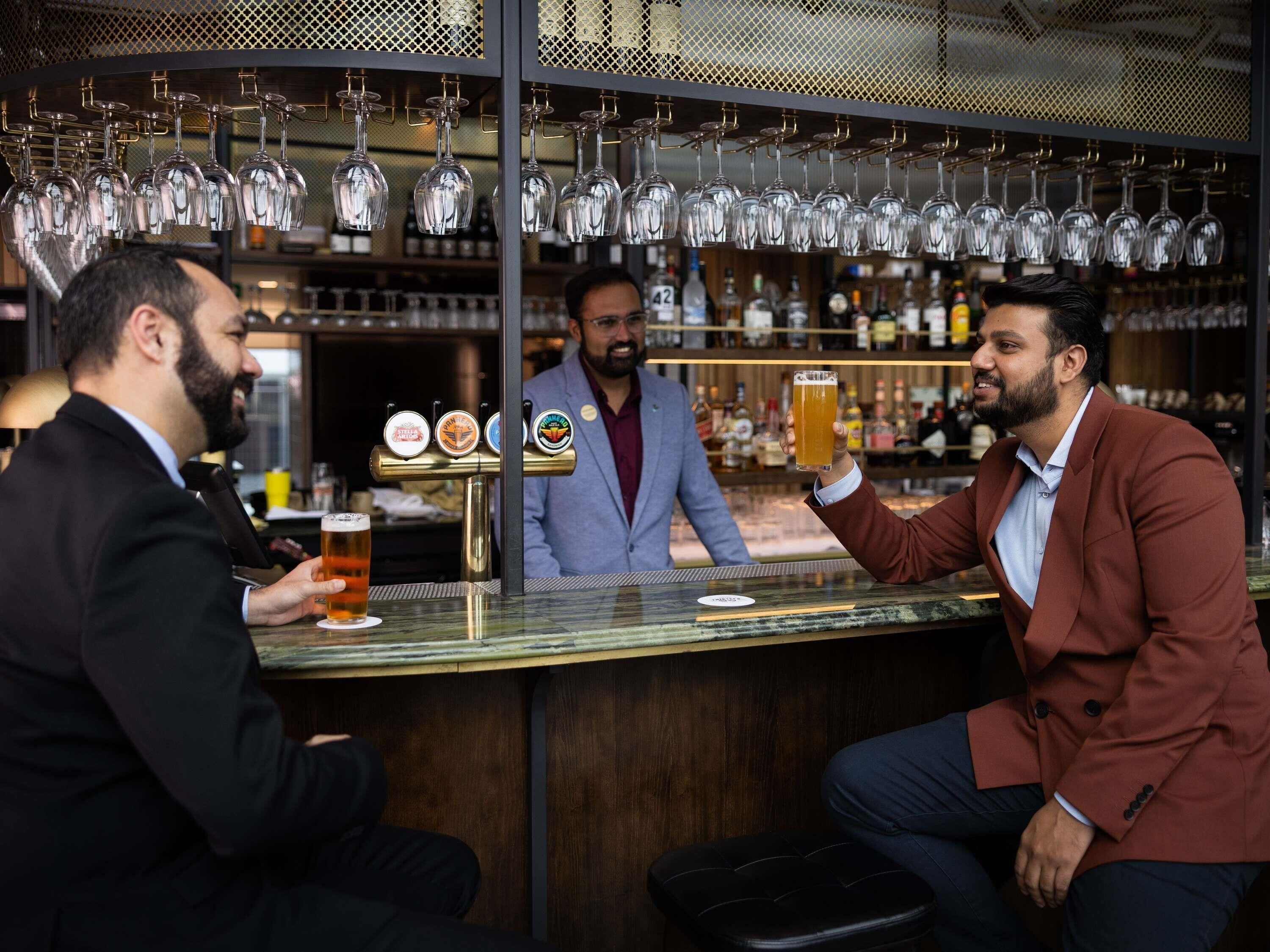Um bar com um bartender atendendo um cliente.