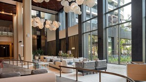 A spacious lobby with modern furnishings, large windows, and hanging spherical light fixtures. - Voyage Belek Golf & Spa (Serik)