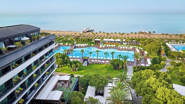 A resort with a large pool, beach access, and a modern building with balconies. - Voyage Belek Golf & Spa (Serik)
