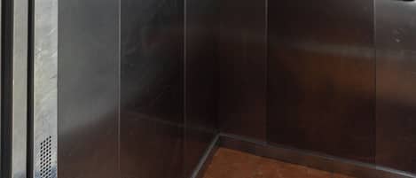 Un ascensor con interior metálico y techo con diseño.